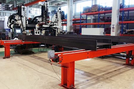 Sistem konveyor transfer opsional mampu mentransfer material seperti balok untuk dimasukkan atau dikeluarkan dari area fabrikasi.
